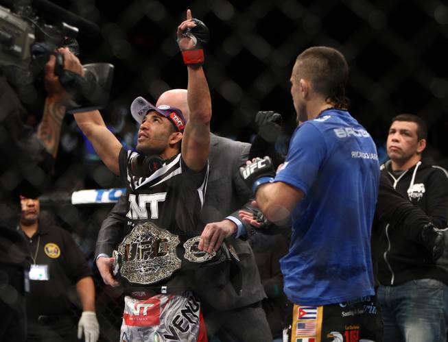 Jose Aldo, left, of Brazil celebrates after beating Ricardo Lamas of Chicago in five rounds of the Ultimate Fighting featherweight championship bout in Newark, N.J., on Saturday, Feb. 1, 2014. Aldo won by unanimous decision.